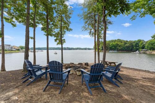 a group of blue chairs sitting next to a lake at Paradise Pointe by AvantStay Lakefront Views Playset in Lake Norman of Catawba