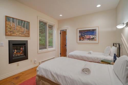 a bedroom with two beds and a fireplace at Manitou River House 113 by AvantStay A Location in Telluride