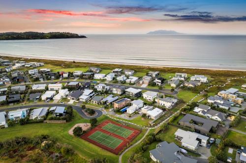an aerial view of a resort next to the beach at The Weekender - Omaha Holiday Home in Warkworth