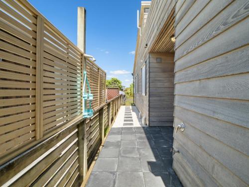 a hallway between two buildings with wooden fences at The Weekender - Omaha Holiday Home in Warkworth