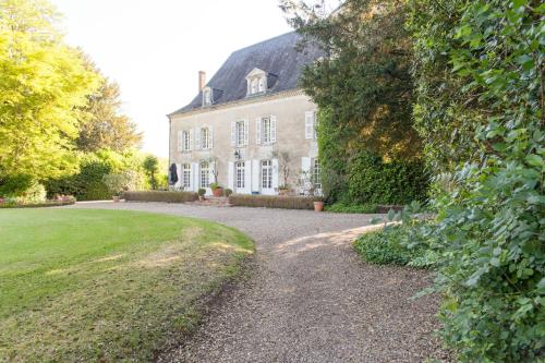a house with a gravel driveway in front of a yard at Domaine Labattut in Saint-Astier