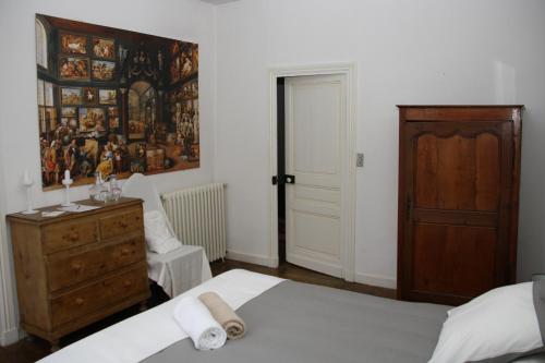 a bedroom with two beds and a dresser and a door at Domaine Labattut in Saint-Astier