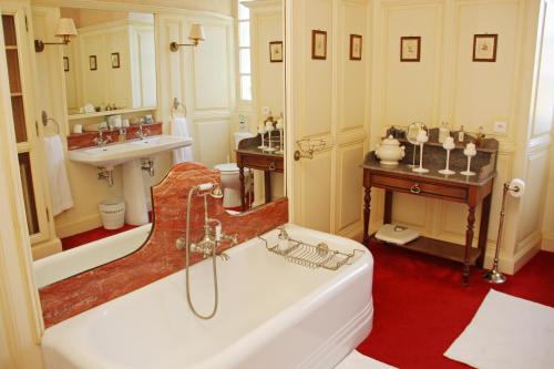 a bathroom with a tub and a sink at Domaine Labattut in Saint-Astier