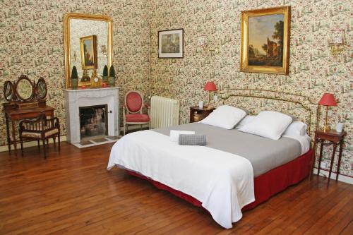 a bedroom with a large bed and a fireplace at Domaine Labattut in Saint-Astier