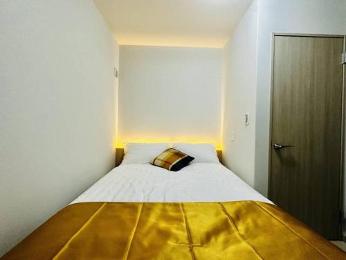 a bedroom with a large bed with a yellow blanket at 新建独栋三层大阪北区两站到梅田 in Osaka