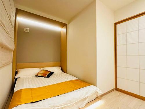 a small bedroom with a bed with a gold headboard at 新建独栋三层大阪北区两站到梅田 in Osaka