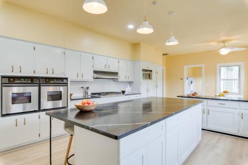 a kitchen with white cabinets and a black counter top at Game Farm Villa by AvantStay 10BDR Private Pond Spa Pool Family-Friendly in Catskill
