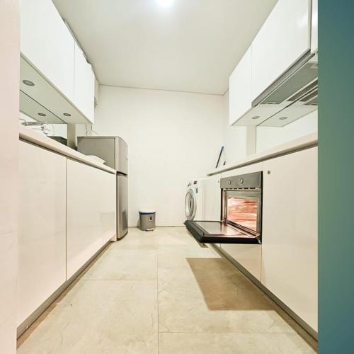 a large kitchen with white walls and stainless steel appliances at Vortex klcc by hr in Kuala Lumpur