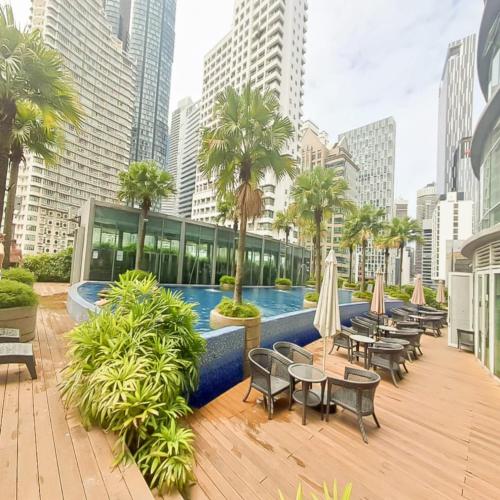 a hotel patio with tables and chairs and a pool at Vortex klcc by hr in Kuala Lumpur