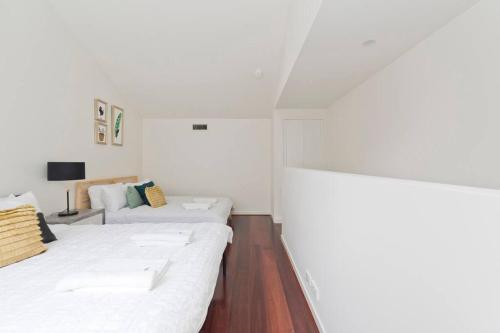 a white room with two beds and a couch at Modern New 3BR Townhouse with Free Parking in Belconnen
