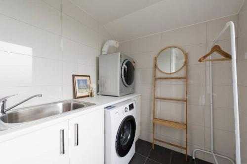 a kitchen with a sink and a washing machine at Modern New 3BR Townhouse with Free Parking in Belconnen