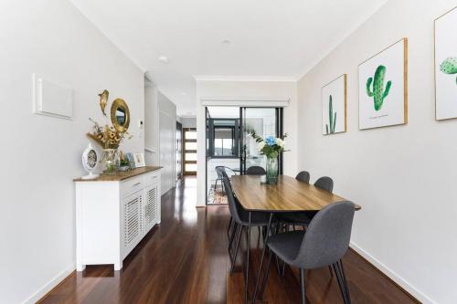 a kitchen and dining room with a table and chairs at Modern New 3BR Townhouse with Free Parking in Belconnen