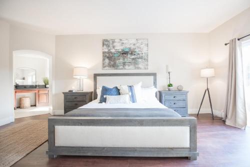 a bedroom with a large bed with blue pillows at Grapevine by AvantStay Secluded 5BR Villa 4 Acres of Vineyards Avo Groves in Temecula
