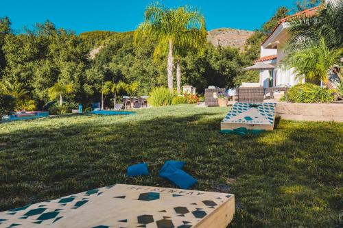 a yard with a table and chairs in the grass at Grapevine by AvantStay Secluded 5BR Villa 4 Acres of Vineyards Avo Groves in Temecula