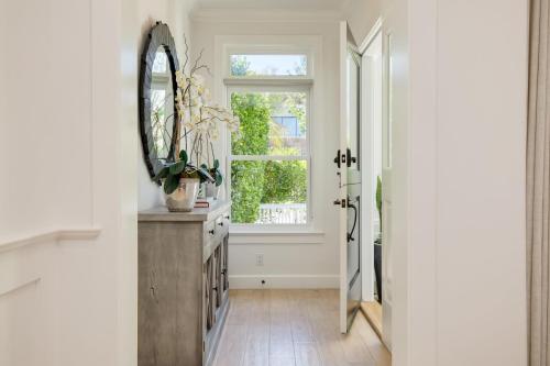 a hallway with a mirror and a window at Emerald Cove by AvantStay Mins to Beach Pier in Newport Beach
