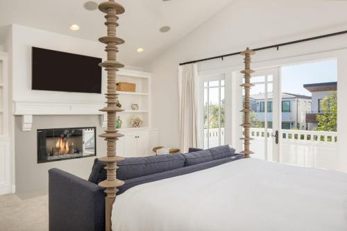 a bedroom with a bed with a fireplace at Emerald Cove by AvantStay Mins to Beach Pier in Newport Beach
