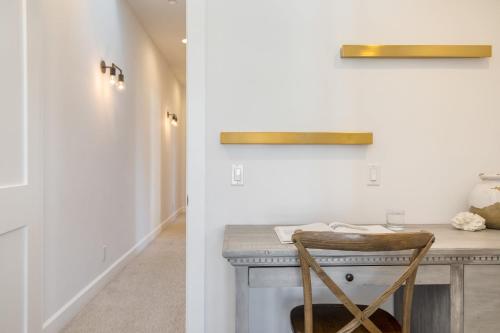 a hallway with a table and a chair at a counter at Emerald Cove by AvantStay Mins to Beach Pier in Newport Beach