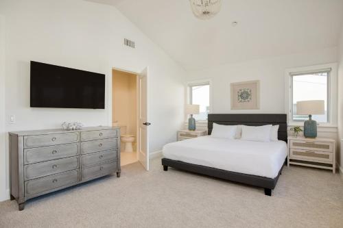 a bedroom with a bed and a television on the wall at Emerald Cove by AvantStay Mins to Beach Pier in Newport Beach