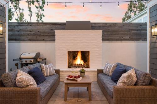 a patio with two couches and a fireplace at Emerald Cove by AvantStay Mins to Beach Pier in Newport Beach