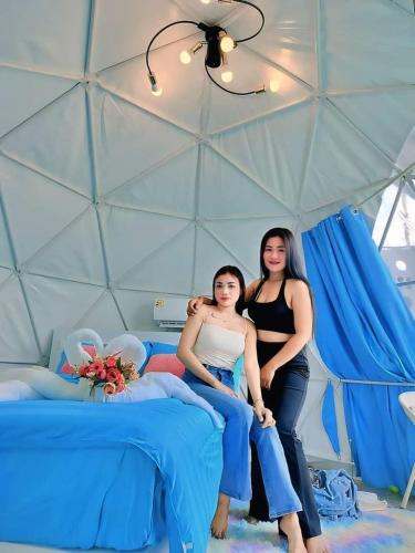 two women sitting on a bed in a tent at อินทนนท์แคมป์ปิ้ง เขื่อนสิรินธร in Sirindhorn