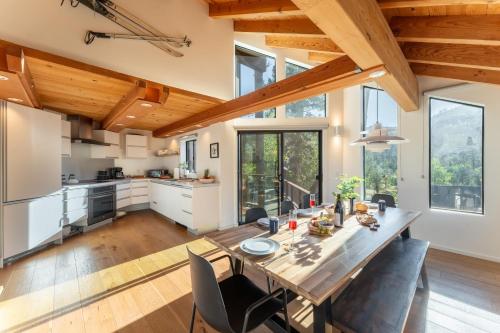 a kitchen and dining room with a wooden table and chairs at Trapper by AvantStay A Interior Design w Sauna in Alpine Meadows
