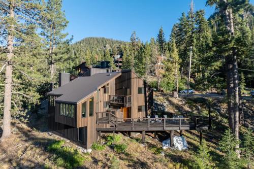 a house on the side of a hill with trees at Trapper by AvantStay A Interior Design w Sauna in Alpine Meadows