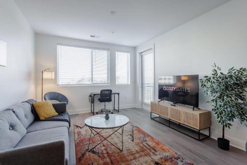TWO Luxe CozySuites in Downtown Cincinnati في سينسيناتي: غرفة معيشة مع أريكة وتلفزيون