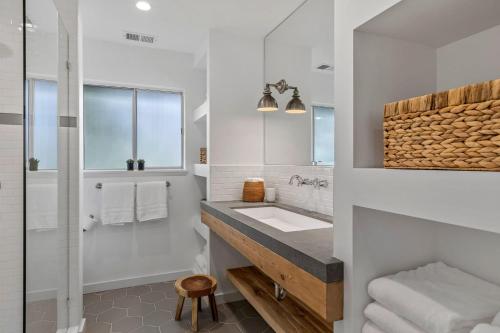 un bagno bianco con lavandino e specchio di Wine Country Estate by AvantStay Pool Spa Barn a Sonoma