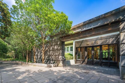 an exterior view of a building with a tree at Hong Qiao State Guest House in Shanghai