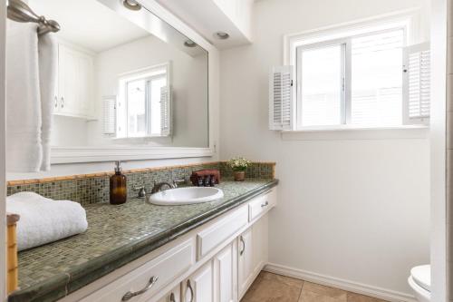 a bathroom with a sink and a mirror at Bay View I by AvantStay Stylish Mission Beach Home on the Sand in San Diego