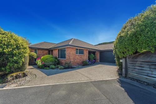 a brick house with a driveway and a garage at Casa Bella - Nelson Holiday Home in Nelson