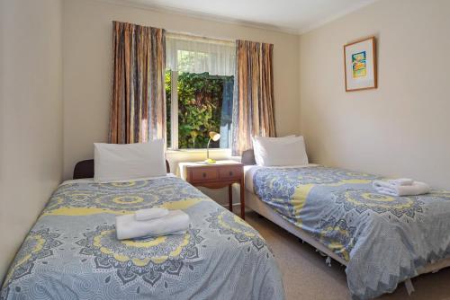 a bedroom with two beds and a window at Casa Bella - Nelson Holiday Home in Nelson