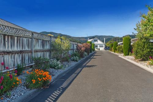an empty street with flowers and a fence at Casa Bella - Nelson Holiday Home in Nelson