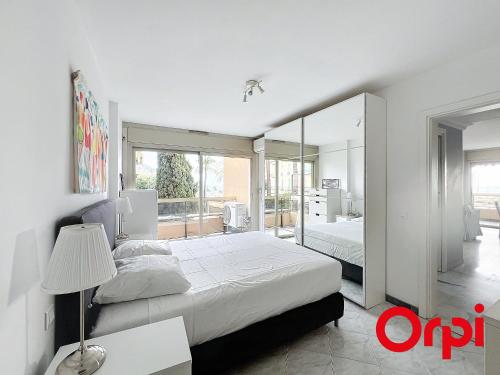 - une chambre blanche avec 2 lits et un miroir dans l'établissement Superbe 2 pièces avec clim, parking et Wifi - FR-1-647-22, à Menton