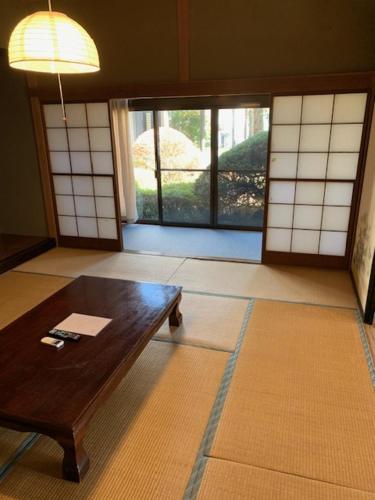 a living room with a wooden table and a window at 景雅はなれ in Yamanakako