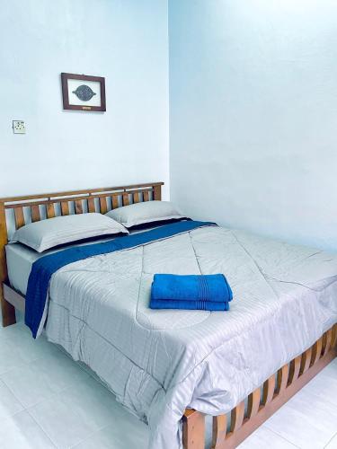a bed with a blue pillow on top of it at D Ocean Homestay in Seri Manjung