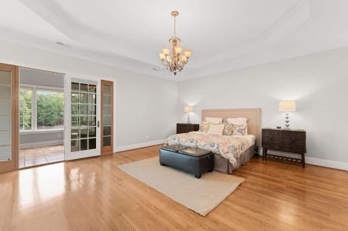 a bedroom with a bed and a table and a chandelier at Whitetail Cove by AvantStay Lakefront w Pool Private Dock Sleeps 20 in Terrell