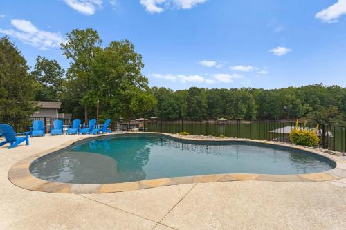 a swimming pool with blue chairs in a yard at Whitetail Cove by AvantStay Lakefront w Pool Private Dock Sleeps 20 in Terrell