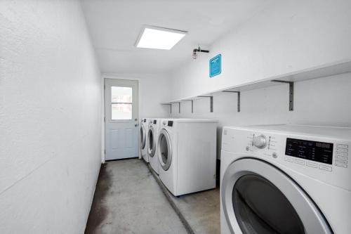 a laundry room with three washing machines in it at Art Deco by AvantStay 1920s Remodeled Bungalow Open Layout Courtyard in Los Angeles