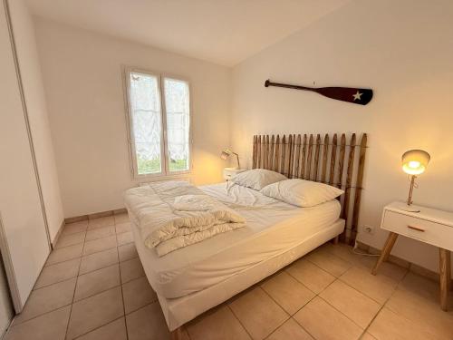 une chambre avec un lit et une lampe sur une table dans l'établissement Maison moderne 200m plage, 4 chambres, jardin privé, Wifi, vélos - Saint-Pierre-d'Oléron - FR-1-778-35, à Saint-Pierre-dʼOléron