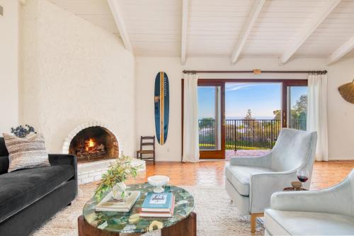 a living room with a couch and a fireplace at Dume Point by AvantStay Tennis Pool in Malibu in Malibu