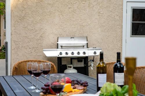 a picnic table with wine glasses and a grill at Dume Point by AvantStay Tennis Pool in Malibu in Malibu