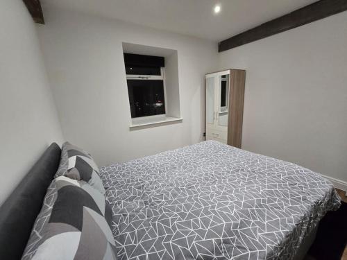a bedroom with a bed and a window at Canalside Period Conversion in Burnley