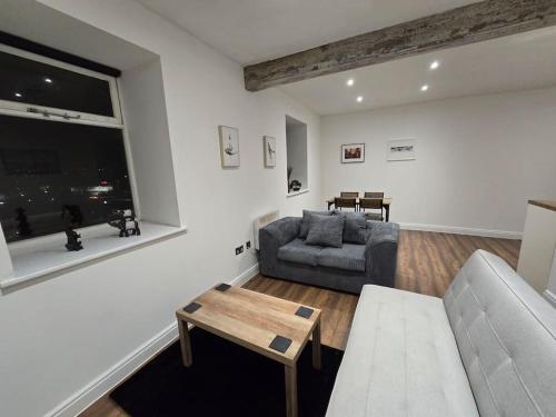 a living room with a couch and a table at Canalside Period Conversion in Burnley