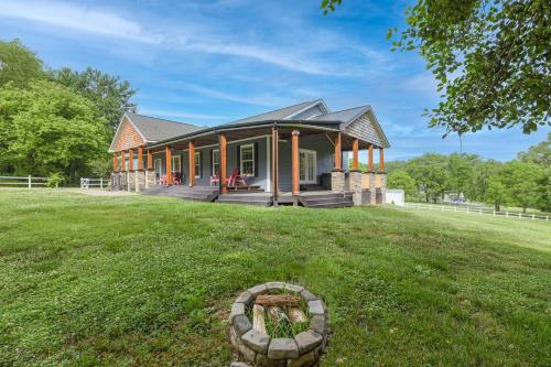 a house on a grassy field in front of a house at Riverside Ranch by AvantStay Mins to Downtown in Arden