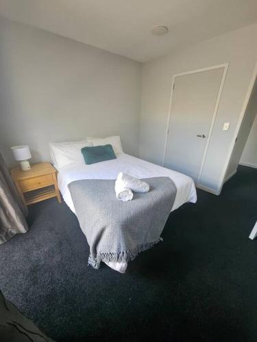 Un dormitorio con una cama con una toalla encima. en Coastal Beach Haven, en Papamoa