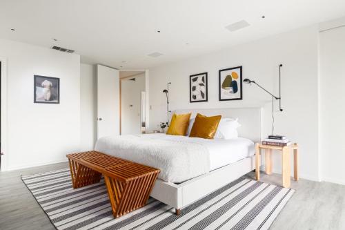 1 dormitorio con cama blanca y mesa de madera en Balboa I by AvantStay - Stylish Condo Balboa Park Adjacent w Views, en San Diego