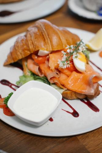 a plate of food with a sandwich on a table at White Whale Beachfront Pool Villa in Ban Bang Po