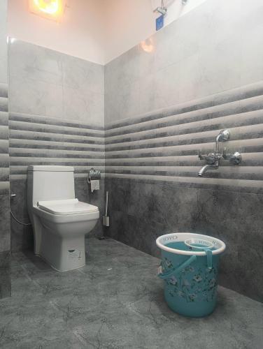a bathroom with a toilet and a bucket in it at Tersha Homestay 2BHK in Shillong