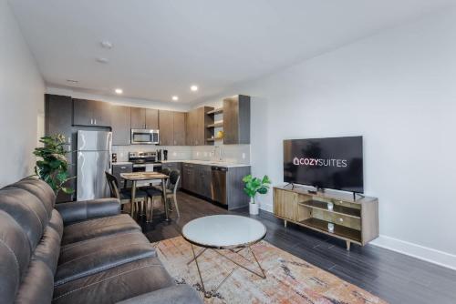 a living room with a couch and a kitchen at Cozysuites l Luxe 2BR in Downtown Cincinnati #4 in Cincinnati